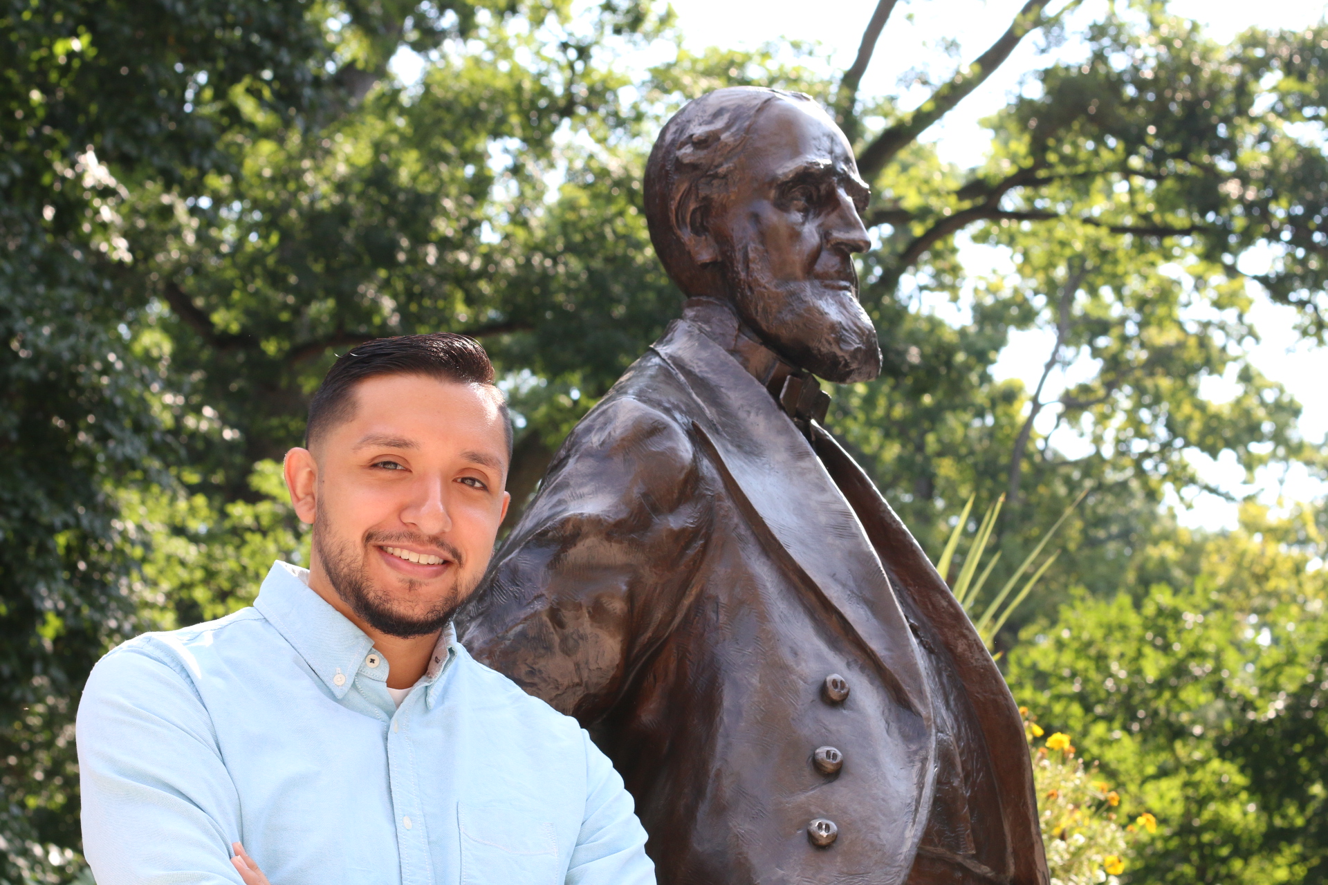 Lehigh Staff Member Chris Herrera shares a photo op with the iconic statue of founder Asa Packer, celebrating earning his master's degree in educational leadership