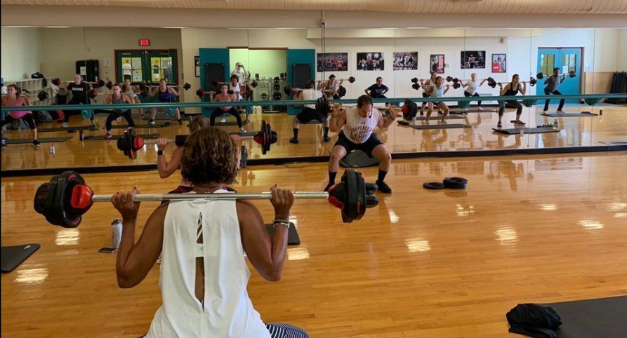 image of a group fitness class in Taylor Gym including the use of free weights