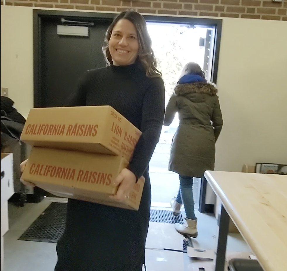 Community Schools Coordinator Paige Hoffman carries cartons of food into the Fountain Hill Elementary School food pantry.