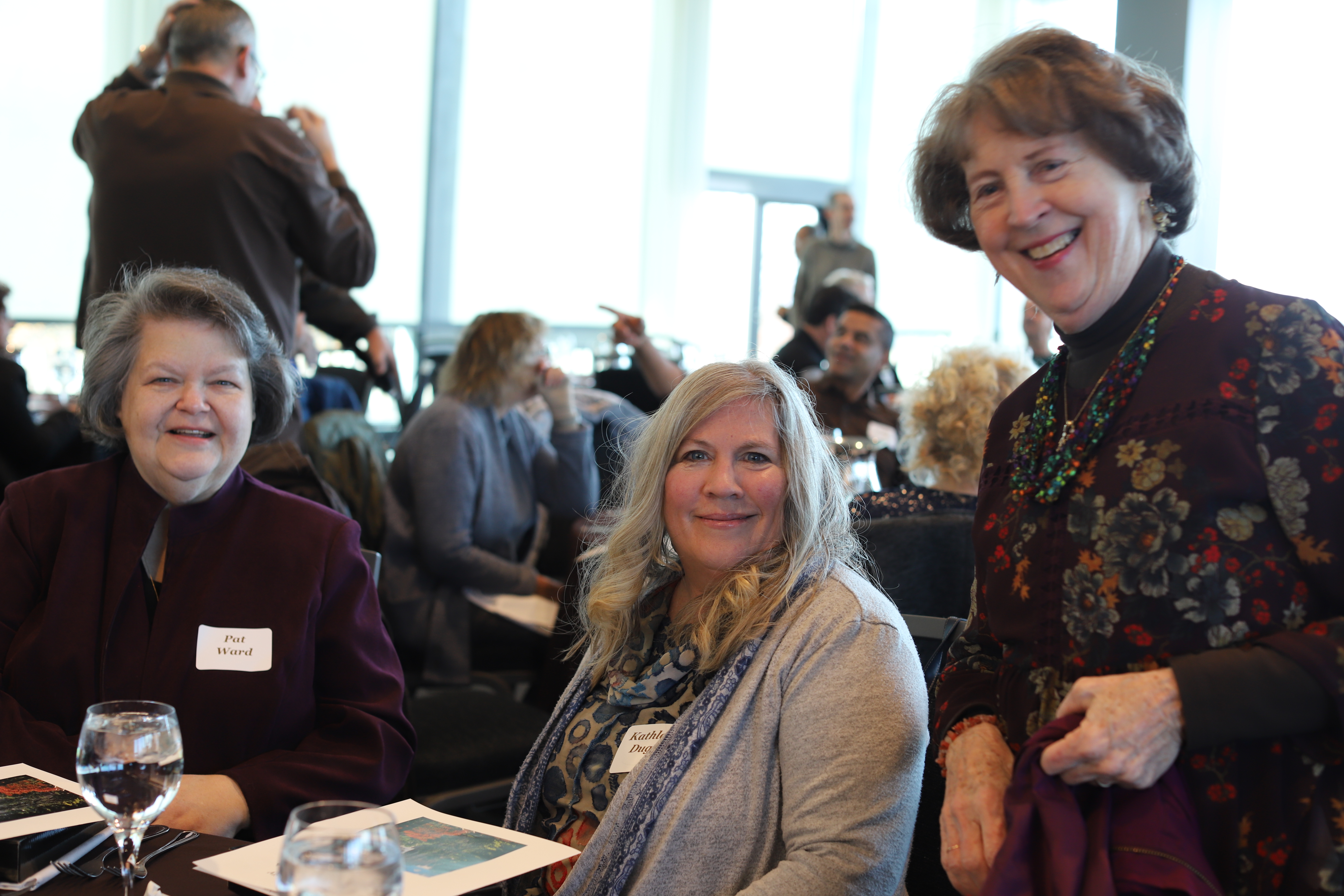 colleagues smile as they reconnect at the 25 year club luncheon in fall 2023