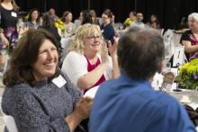 smiling employees celebrate their colleagues at the annual staff appreciation dinner