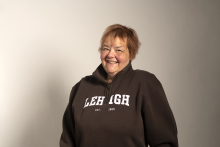 an image of MaryAnn Haller, a longtime Lehigh employee who passed away in November 2022. She is wearing a cozy brown Lehigh fleece sweater and smiling warmly.
