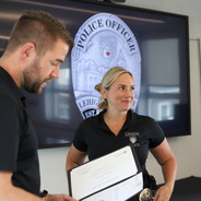 Lehigh Police Officer Jaime Leauber looks at her colleagues as her supervisor Sergeant Kyle Fischer reads Jaime's Spot Bonus Award citation to her.