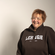 an image of MaryAnn Haller, a longtime Lehigh employee who passed away in November 2022. She is wearing a cozy brown Lehigh fleece sweater and smiling warmly.